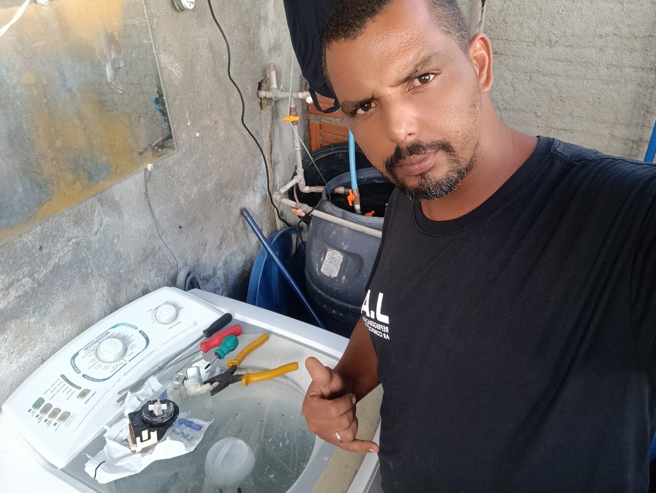 Jaime realizando manutenção em lavadora