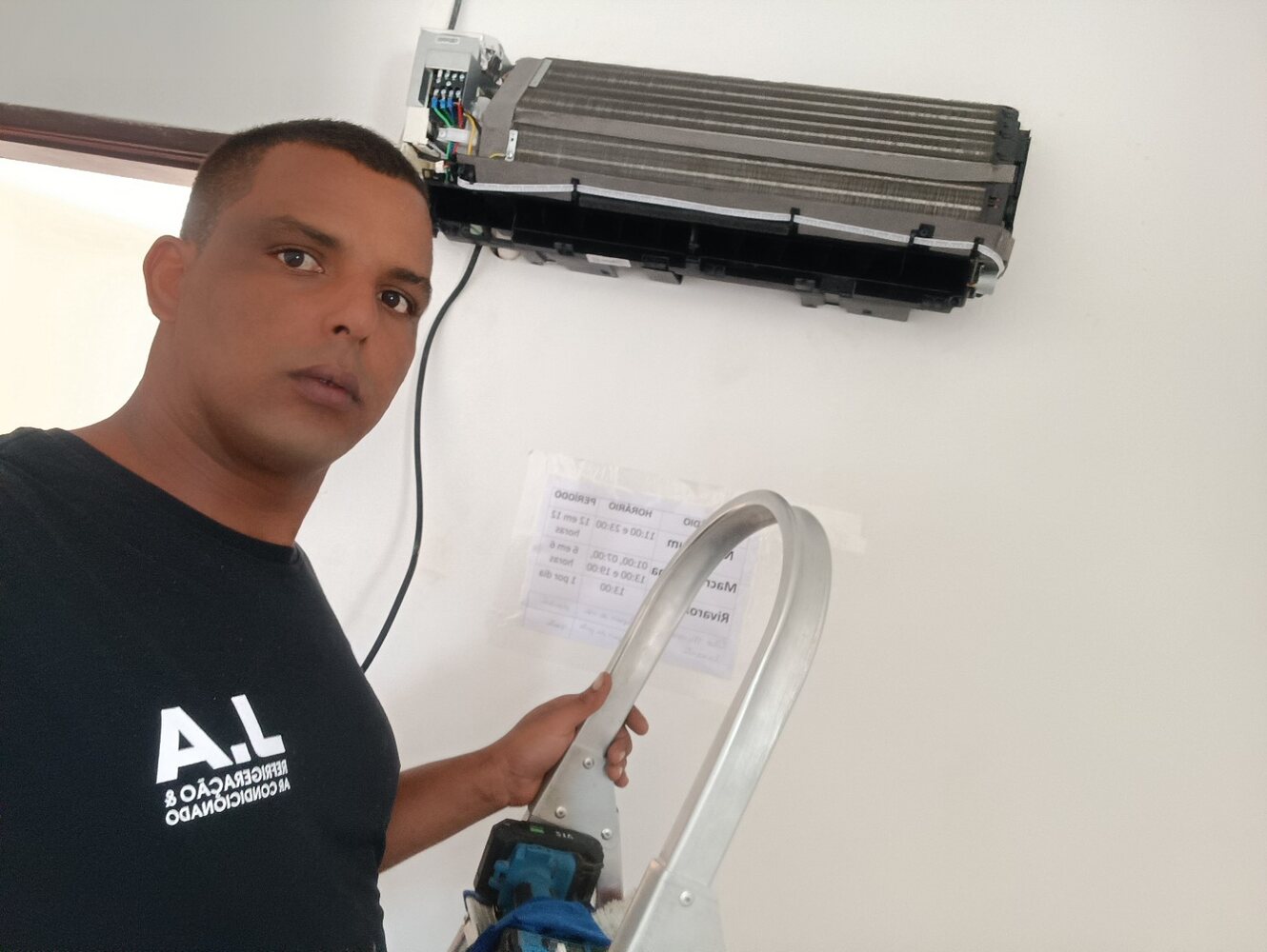 Jaime realizando manutenção em ar-condicionado split